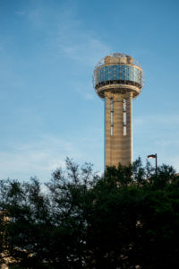 The upper half of Reunion Tower rises above the treeline. La Reunion would have been west, across the Trinity River.