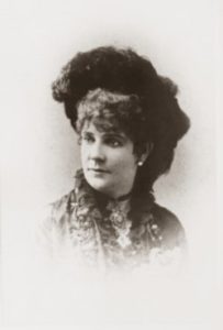 A black and white photo of our honorary dallasite is shown here - she is in 3/4 profile, youthful, with a large hat and many accessories.