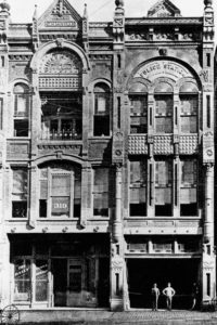 Black and white image of side by side buildings of the Times Herald and the police station, both are very baroque in their decoration. To be nevermore.