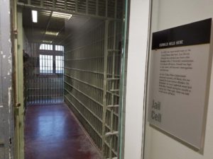 A view of the jail cell that were part of the police department on harwood street are shown here with a window illuminating one end.