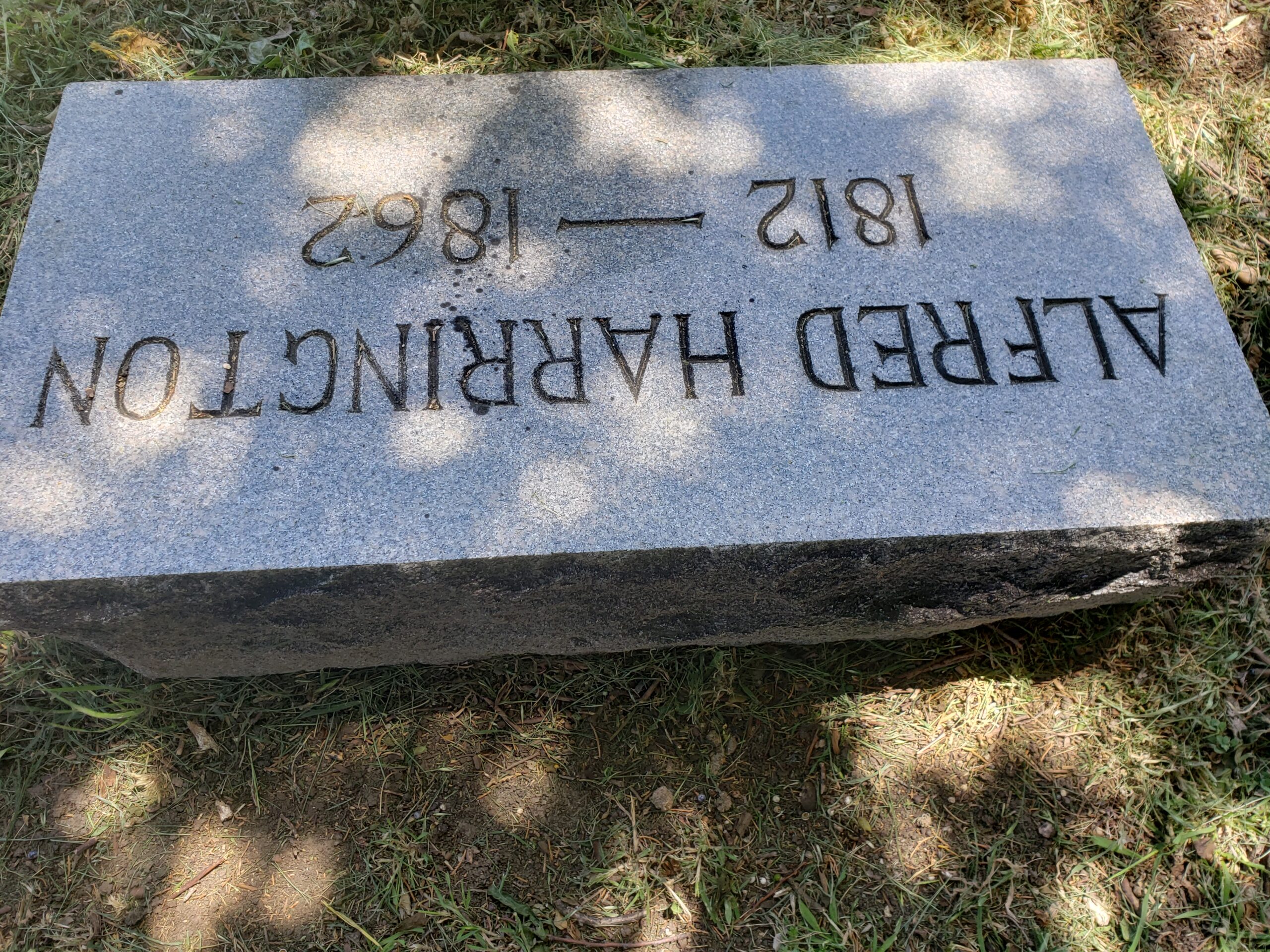 The very plain block headstone of Alfred Harrington in Rowlett Creek Cemetery.